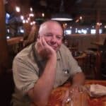 Smiling man sitting in a cozy restaurant.