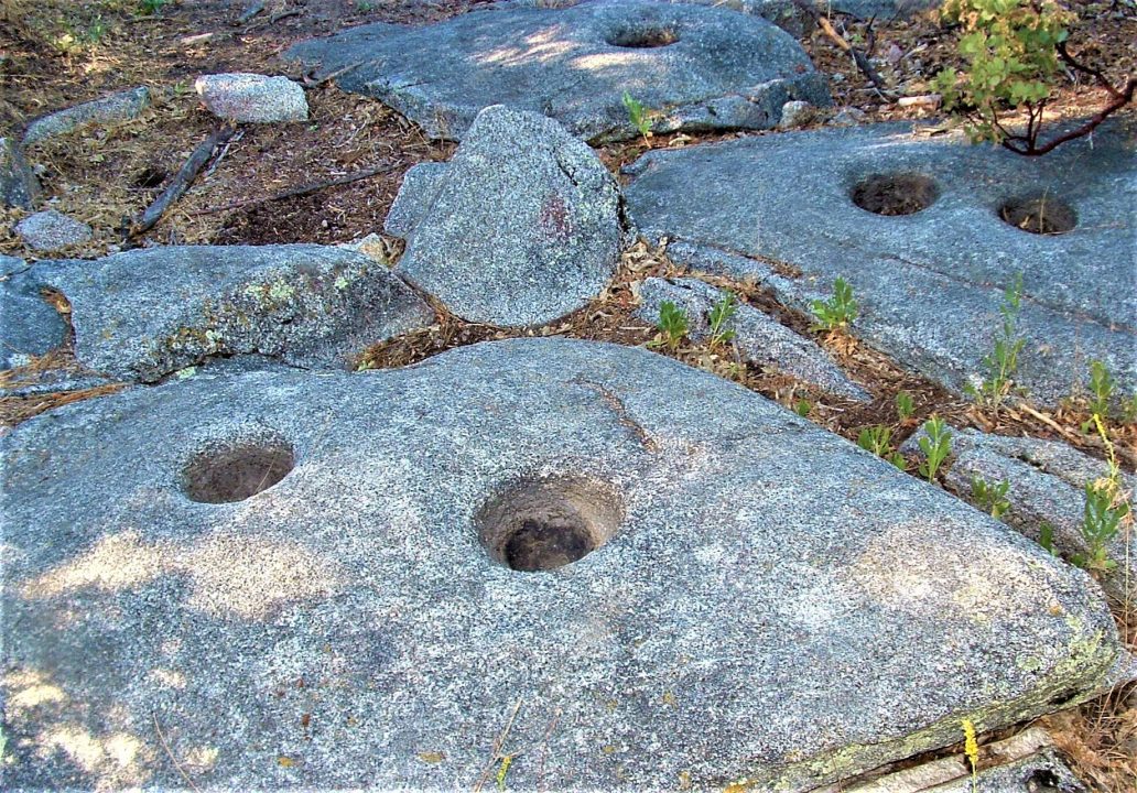 Ancient grinding holes in rocky landscape.