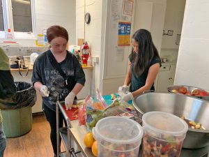 Scarlett and Charlotte cut apples for the chicken dish and the fruit salad.