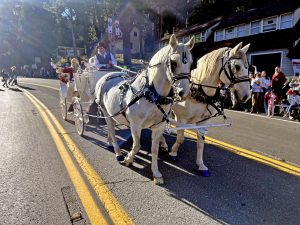 Santa and Mrs. Claus arrived in a carriage drawn by two white horses.