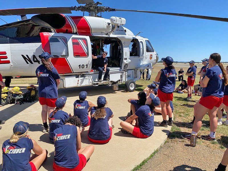 Adrianne, Lisa, Julia, Melissa and Adrianna from Glendora and Orange County enjoyed last year’s Brewfest at Tavern Bay Beach Club so much they couldn’t resist attending this year’s event. (Photos by Douglas W. Motley) Group learning beside helicopter outdoors.