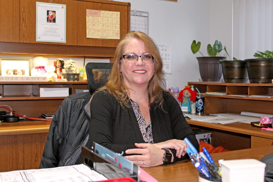 Smiling woman sitting at a wooden office desk