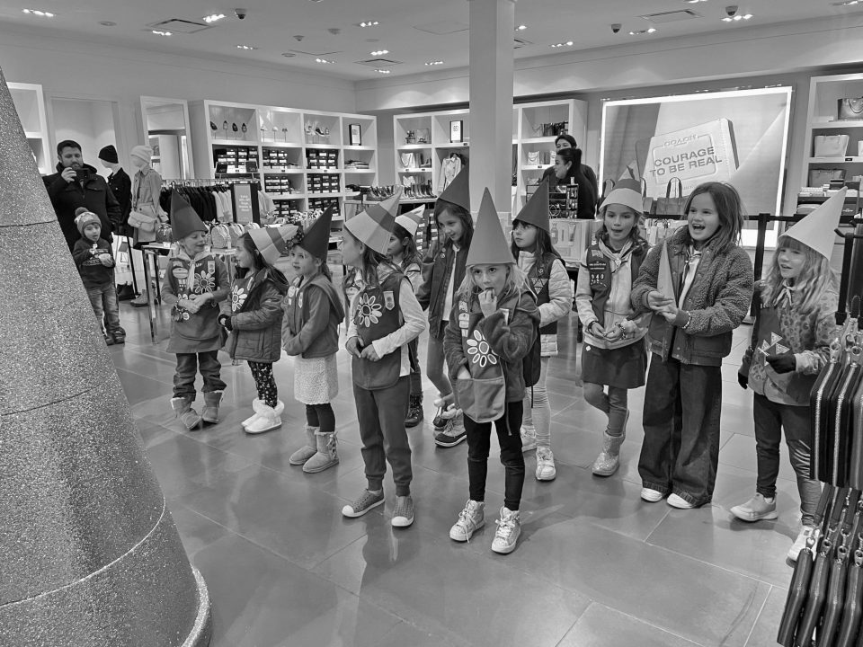 Group of children in hats inside a store.