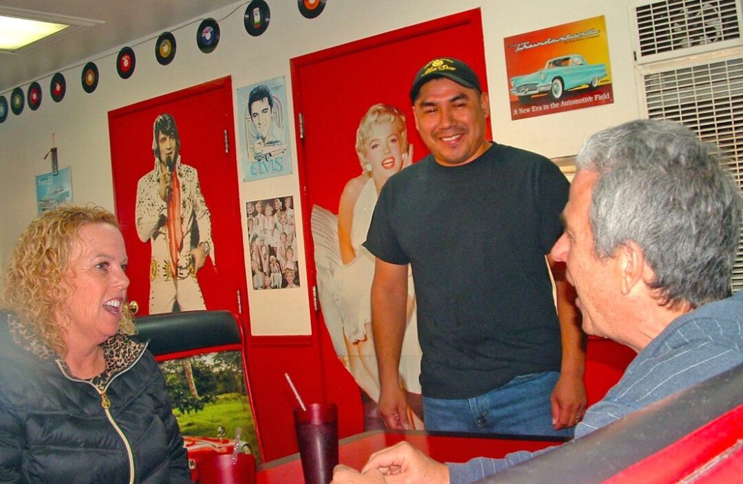Three people chatting in retro diner