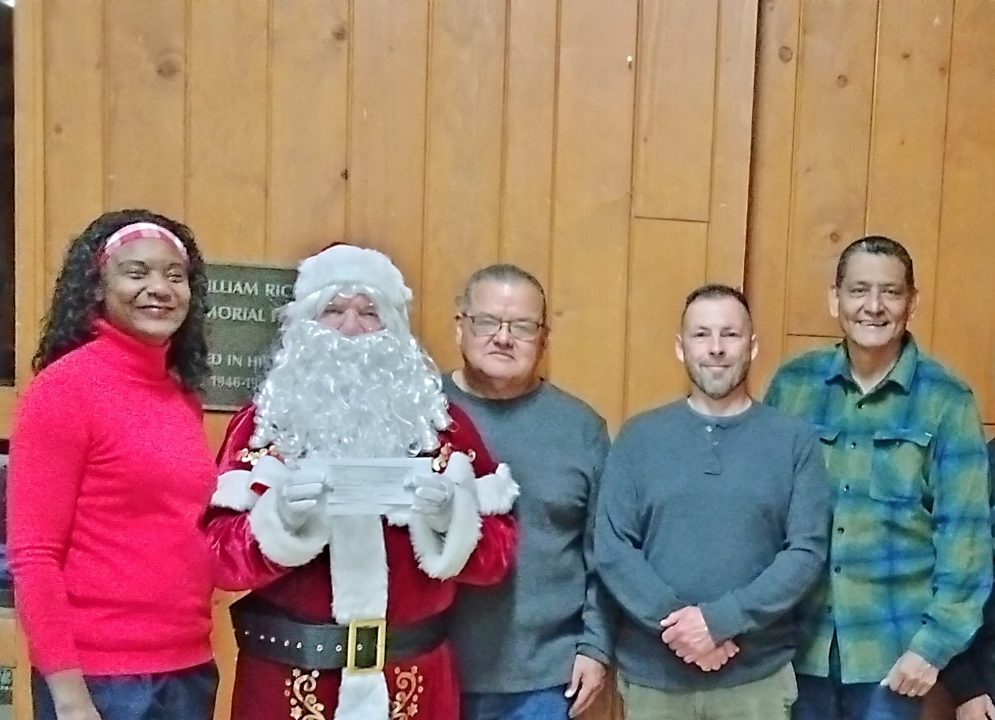 Adrianne, Lisa, Julia, Melissa and Adrianna from Glendora and Orange County enjoyed last year’s Brewfest at Tavern Bay Beach Club so much they couldn’t resist attending this year’s event. (Photos by Douglas W. Motley) Group with Santa holding a check indoors.