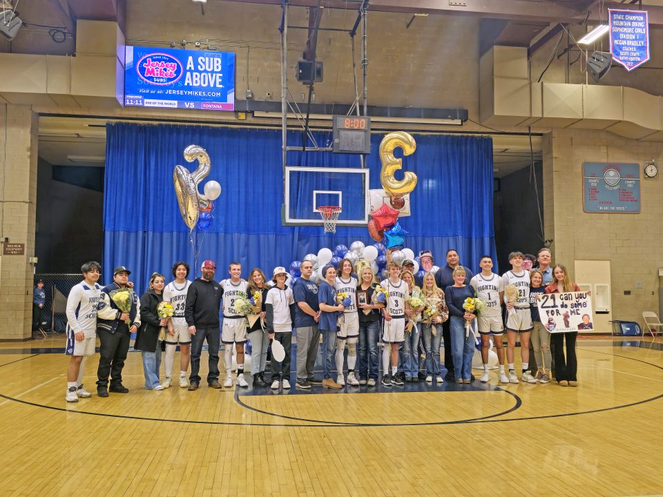 Basketball team and family celebrate Senior Night in gym.