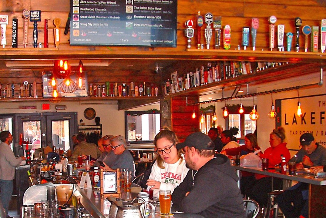 Adrianne, Lisa, Julia, Melissa and Adrianna from Glendora and Orange County enjoyed last year’s Brewfest at Tavern Bay Beach Club so much they couldn’t resist attending this year’s event. (Photos by Douglas W. Motley) People socializing at a lively bar with drinks