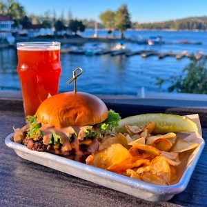 The Tap Room burger, shown here with a glass of craft beer, is the restaurant’s signature handheld meal. (Photo courtesy of The Lakefront Tap Room Bar and Kitchen)