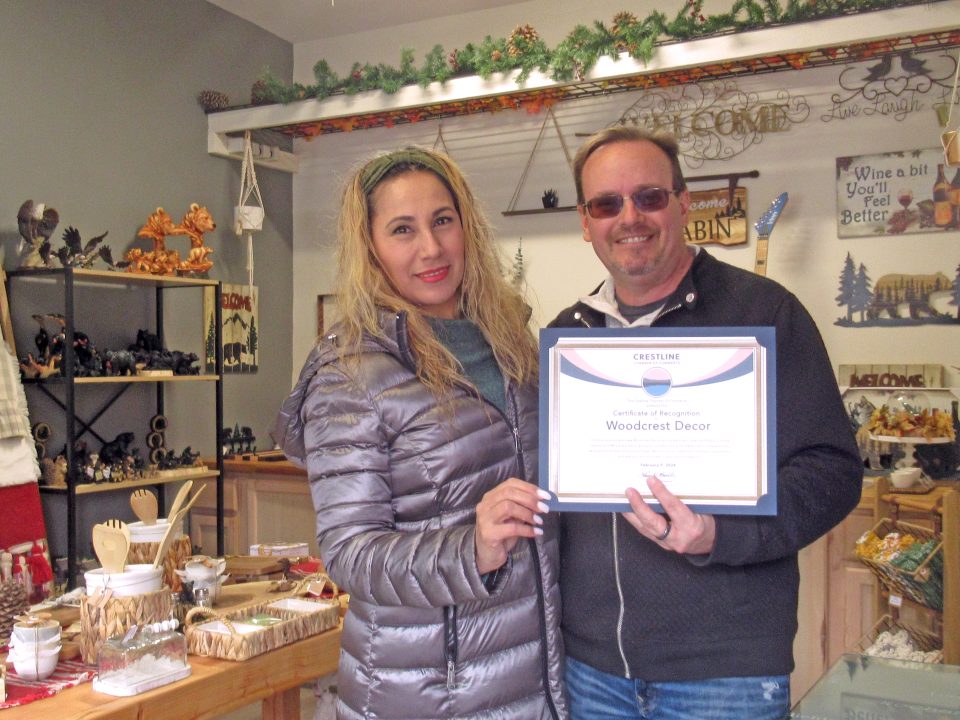 Inside Woodcrest Décor, owners Jeff Heitmann and Lidia Pena hold their ribbon cutting certificate presented to them by the Crestline Chamber of Commerce.