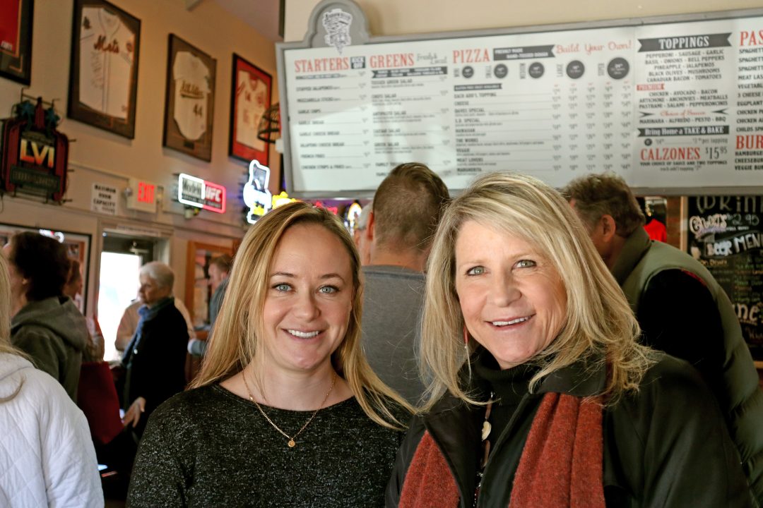Adrianne, Lisa, Julia, Melissa and Adrianna from Glendora and Orange County enjoyed last year’s Brewfest at Tavern Bay Beach Club so much they couldn’t resist attending this year’s event. (Photos by Douglas W. Motley) Two women smiling inside a busy pizzeria.