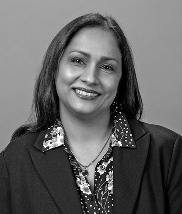 Smiling woman in business attire, black and white photo.