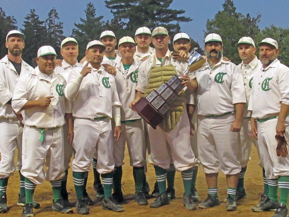 Vintage baseball team poses with a trophy.