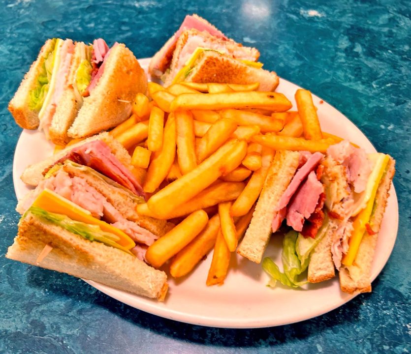 Club sandwich with French fries is a stellar lunch order.