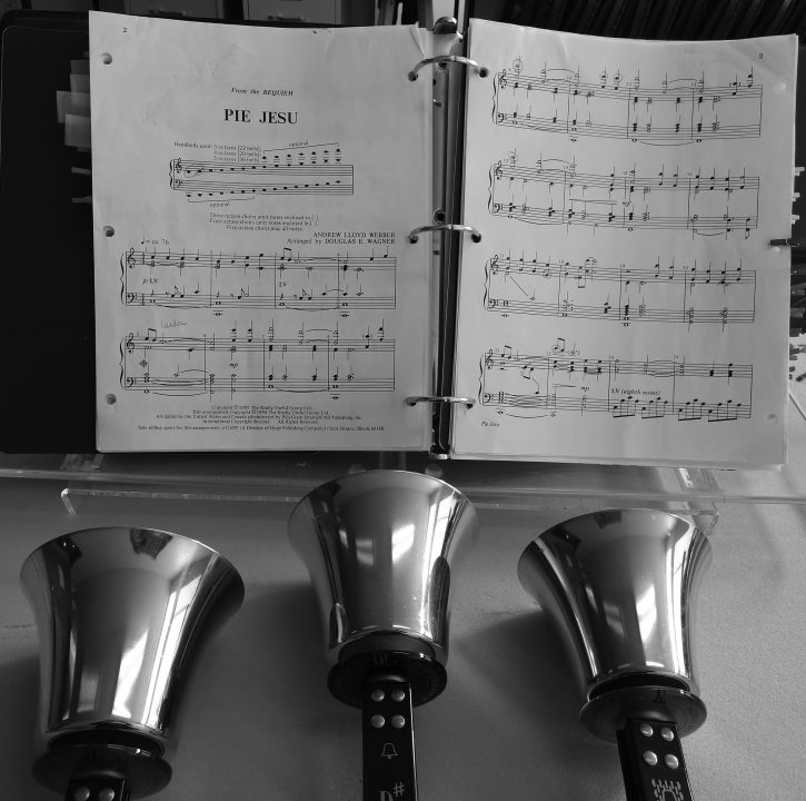 Sheet music open with handbells below.