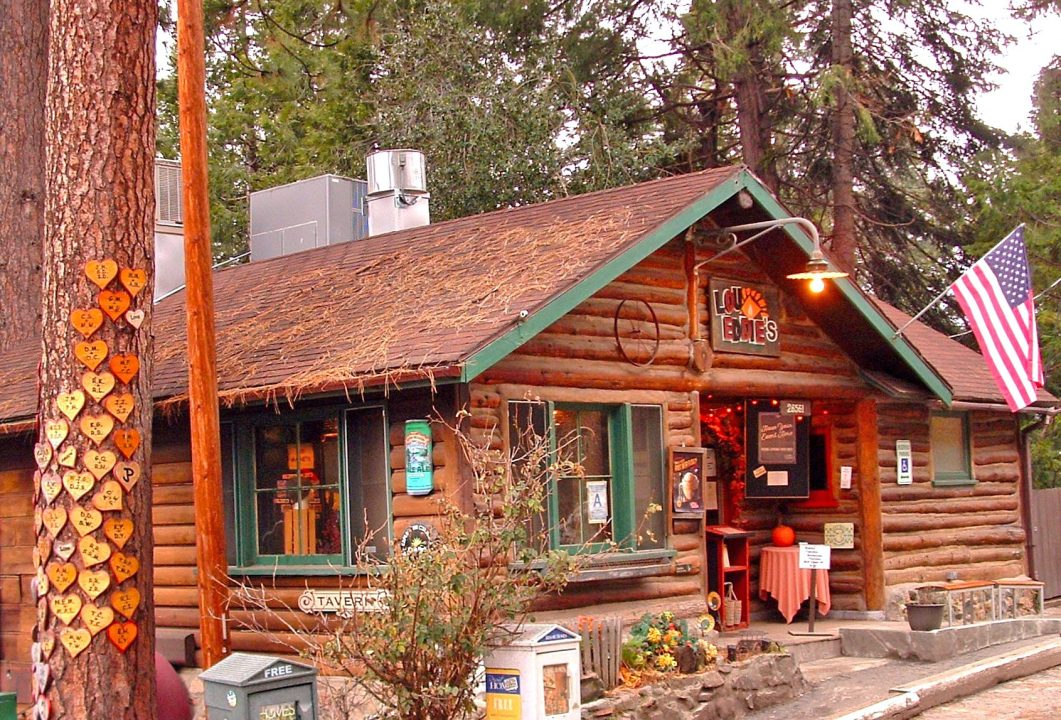 LouEddie’s Pizza is housed in a sturdy cabin that was built in 1923. It’s part of historic Willow Woods Park. At left is the park’s “Love Tree,” with hearts bearing the initials of couples who’ve been married there. (Photo by T. Wilcox)