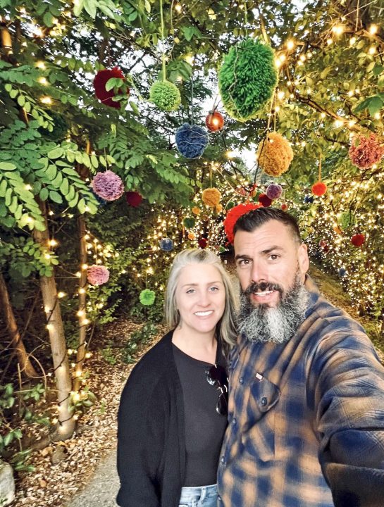 Adrianne, Lisa, Julia, Melissa and Adrianna from Glendora and Orange County enjoyed last year’s Brewfest at Tavern Bay Beach Club so much they couldn’t resist attending this year’s event. (Photos by Douglas W. Motley) Couple smiling under festive, colorful tree lights.