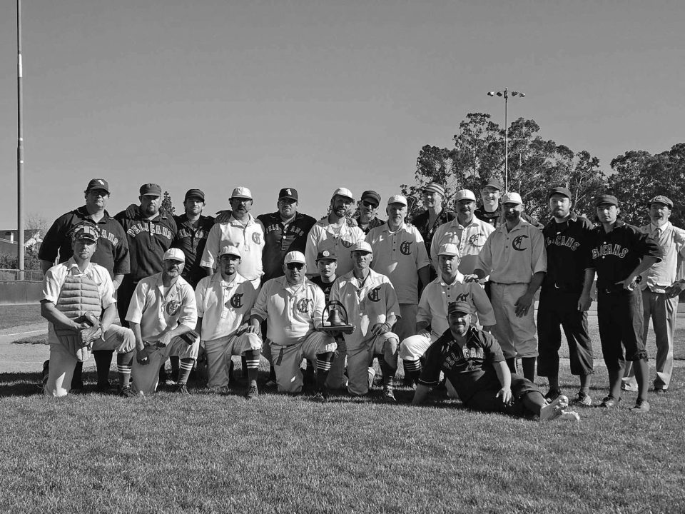 Vintage baseball team poses on grass field.