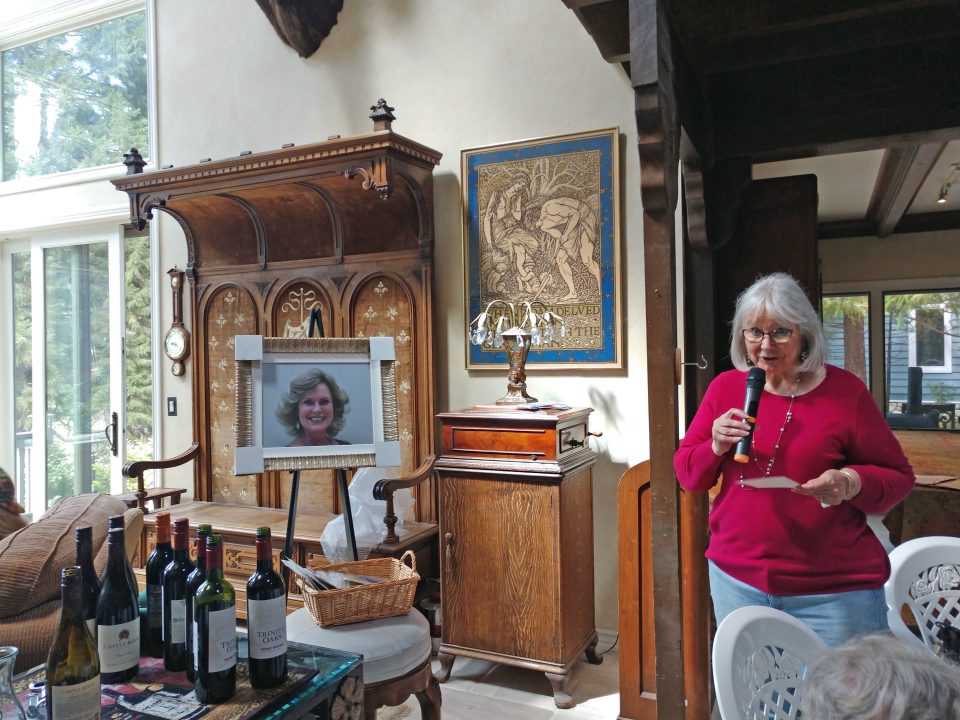 Woman speaking at indoor event with microphone.