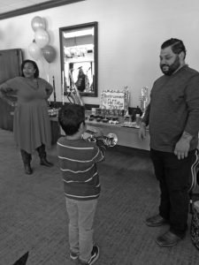 Karissa and Kirk from Music & Arts watch as 8-year-old Karissa and Kirk from Music & Arts watch as 8-year-old Reuben tries his hand at the trumpet.