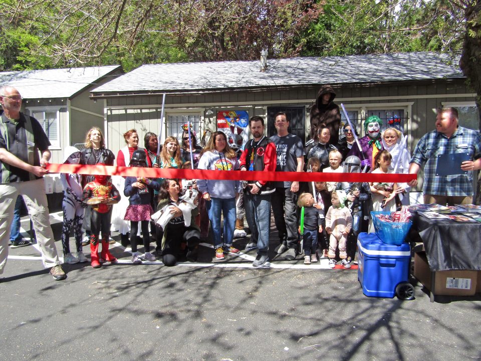 Costumed group at comic event ribbon-cutting ceremony.