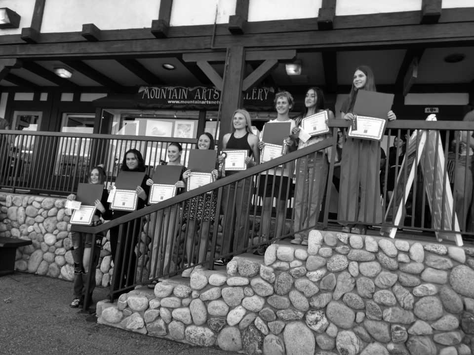 Group of people holding certificates on stone steps.