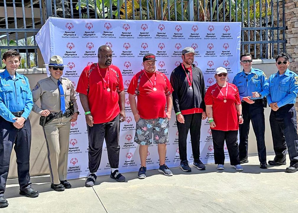 The mountain’s bronze medal winners Cedric Obonyano, Michael Gladwell,Madison Meares and Hayley Haugland are flanked by law enforcement officers at the Fontana event.