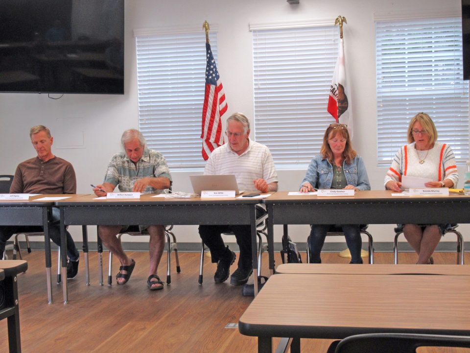 Five people sitting at a meeting table.