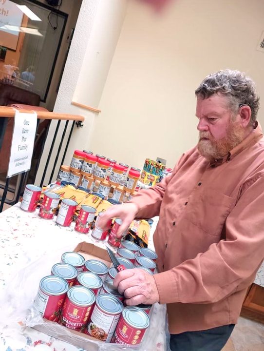 Mike Riseley, a volunteer at the Community Food Pantry, sorts donated food distributed every Sunday morning at the Crestline Seventh-Day Adventist Church.