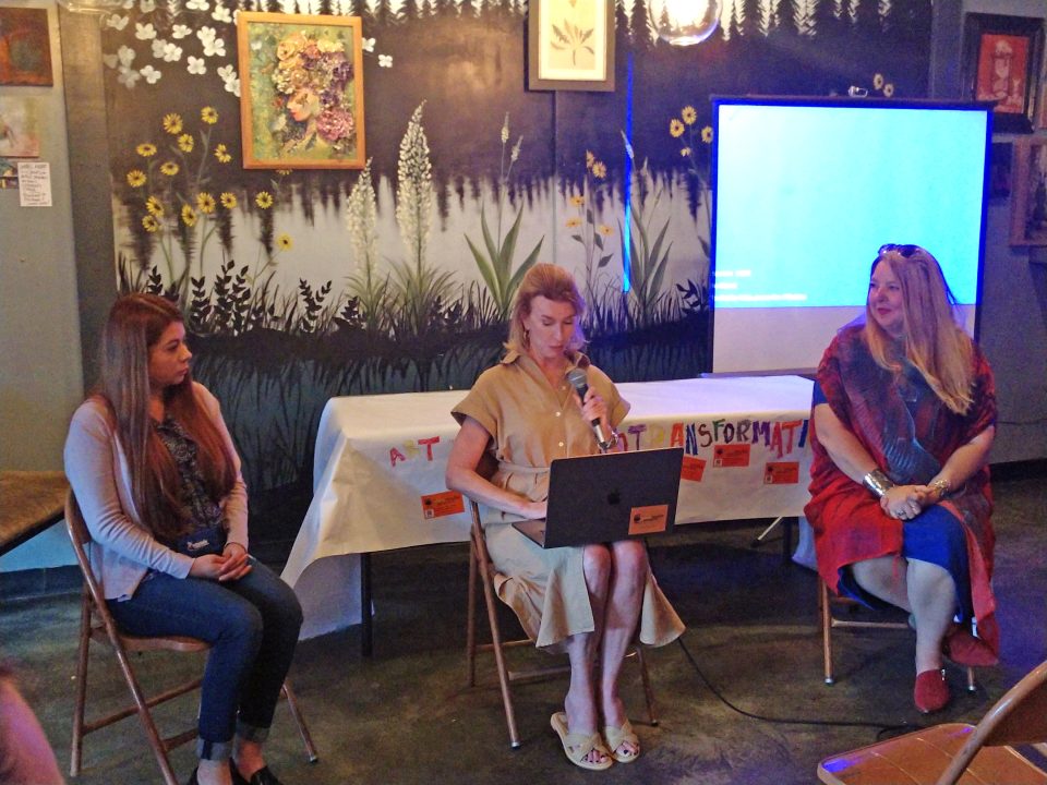Three women in discussion at creative workshop.