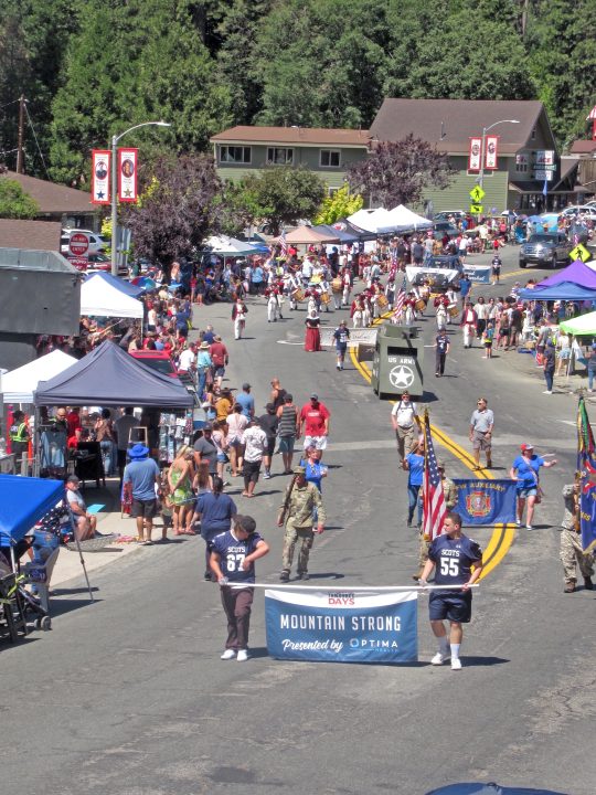 Street festival with people, banners, and booths.