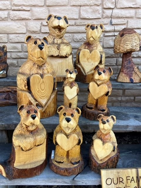 Carved wooden bear family with heart designs.