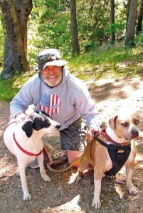 Hugh James Rochford, an Orange County resident who lives in Tustin, has had a getaway home in Agua Fria for 27 years. A finish carpenter and contractor poised to retire, Hugh has visited this forest and its trails too many times to count. He’s an Air Force veteran who’s rescued a number of dogs. Pictured here are two of them: Sammy (right) and Peewee.