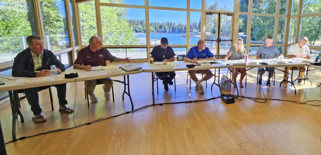 People in meeting room with lake view.