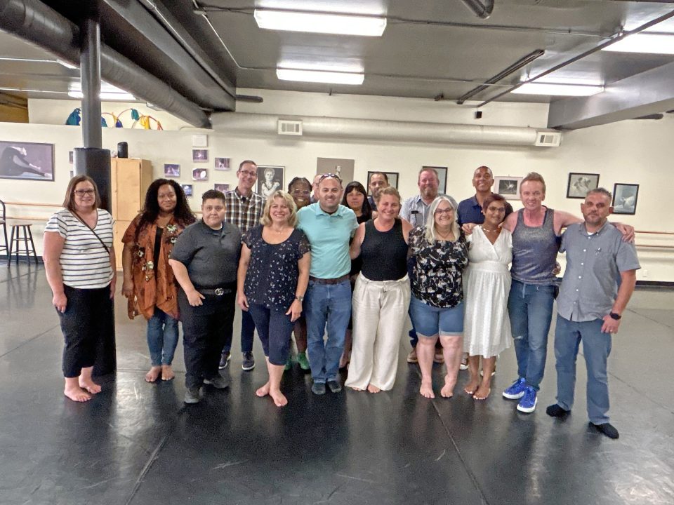 Group of people smiling in a dance studio.