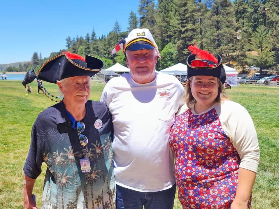 Three people in hats at outdoor festival