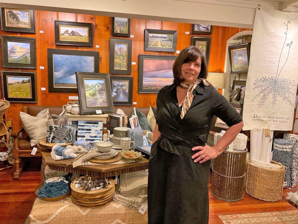 Gallery exhibit with paintings and decorative items.