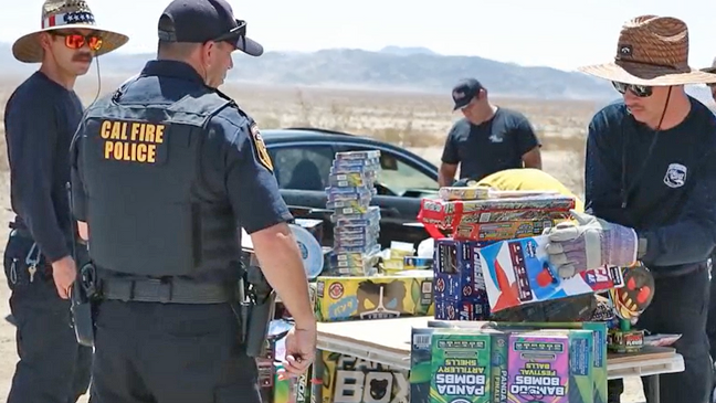 Fire police inspecting fireworks on outdoor table.