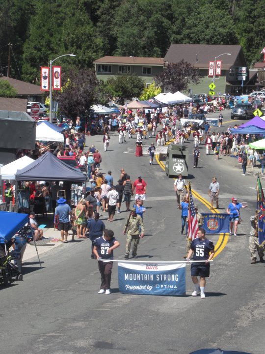 Street parade with participants and banners on display.