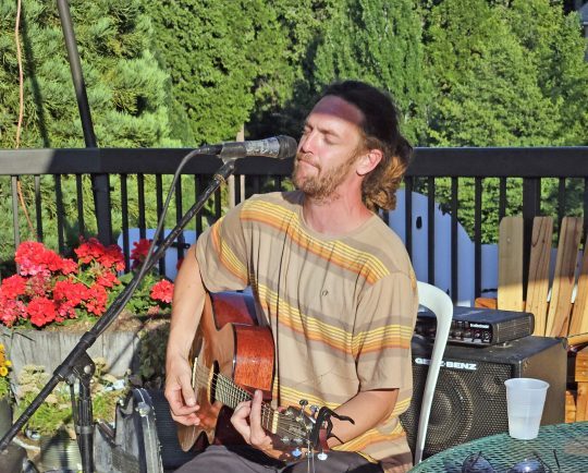 Man playing acoustic guitar outdoors