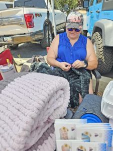 Angela finger knits blankets and beanies she has for sale at the market
