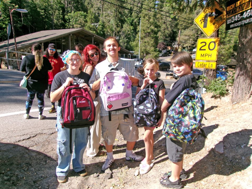 A family showing off their new backpacks.
