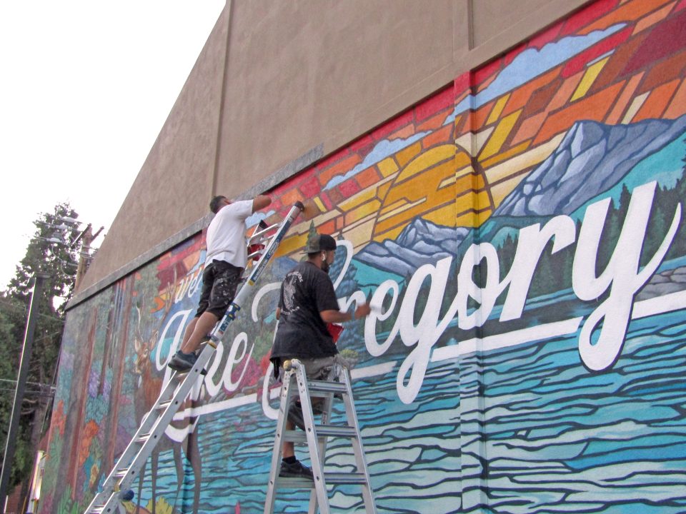 Wes Abarca (at top of the ladder) is seen with Luis Solanos putting the finishing touches on his recently painted Lake Gregory Village mural.