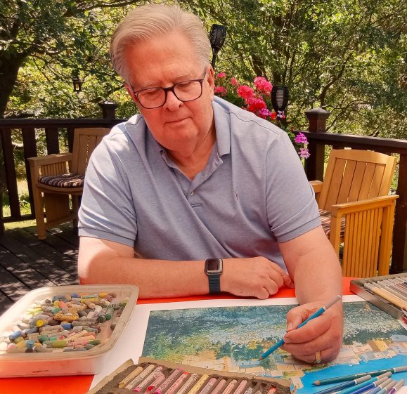 Man drawing with pastels outdoors on a sunny day.