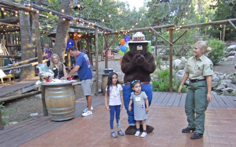 Adrianne, Lisa, Julia, Melissa and Adrianna from Glendora and Orange County enjoyed last year’s Brewfest at Tavern Bay Beach Club so much they couldn’t resist attending this year’s event. (Photos by Douglas W. Motley) Smokey Bear with children and park ranger outdoors.