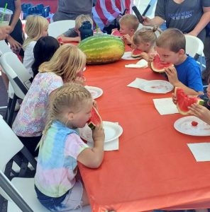 Children enjoying a watermelon eating contest.