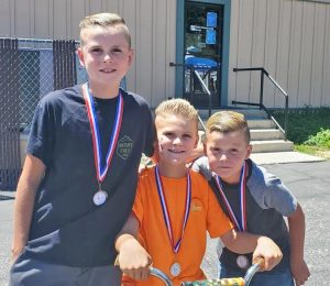 The Hyatt brothers swept the bike race competition with 7-year-old Rev (right) taking third, 10-year-old Roland (left) taking second, and 9-year-old Riggs (seated) taking first place.