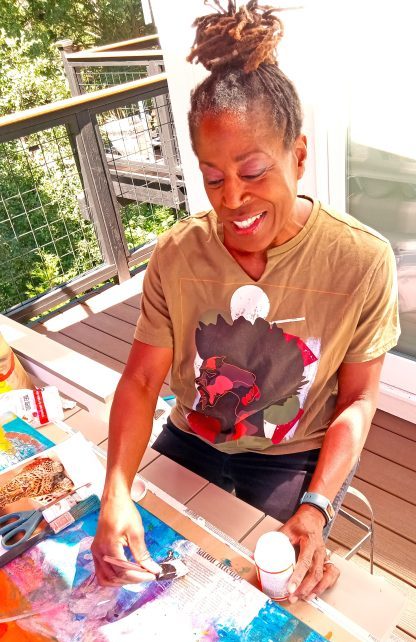 Person painting art outdoors on a sunny day.