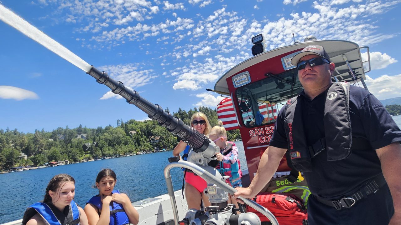 Adrianne, Lisa, Julia, Melissa and Adrianna from Glendora and Orange County enjoyed last year’s Brewfest at Tavern Bay Beach Club so much they couldn’t resist attending this year’s event. (Photos by Douglas W. Motley) Family on boat with water cannon, sunny lake scene.