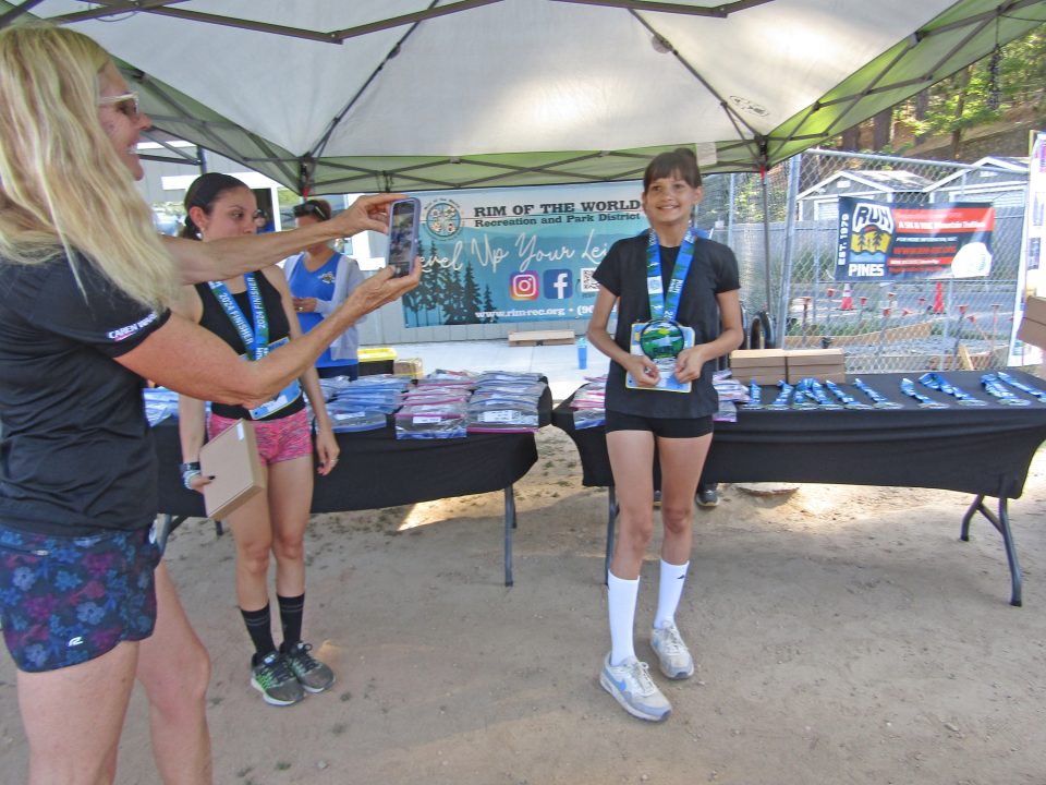 A proud mom takes a photo of 12-year-old MPH student Brooke Bracamonte, who garnered a first-place trophy.