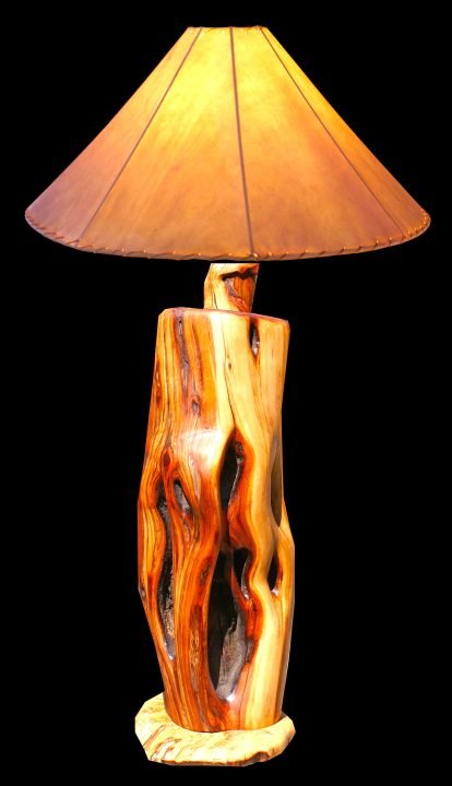 This lamp was made from a raw manzanita stump. The purple-gray bark was sanded off to reveal the interior golden brown, purple and blonde striations.